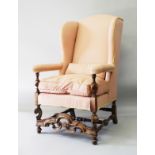 A QUEEN ANNE STYLE UPHOLSTERED WING ARMCHAIR, 20TH CENTURY, with rounded top, padded arms, on turned