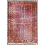 A TEKKE RUG, claret ground, double central motif, double border. 8ft x 5ft 5ins.