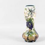 A MOORCROFT VASE with flowers in relief. 11ins high.