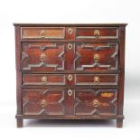 A 17TH CENTURY OAK CHEST OF DRAWERS, in two parts, with four long drawers, brass drop handles on
