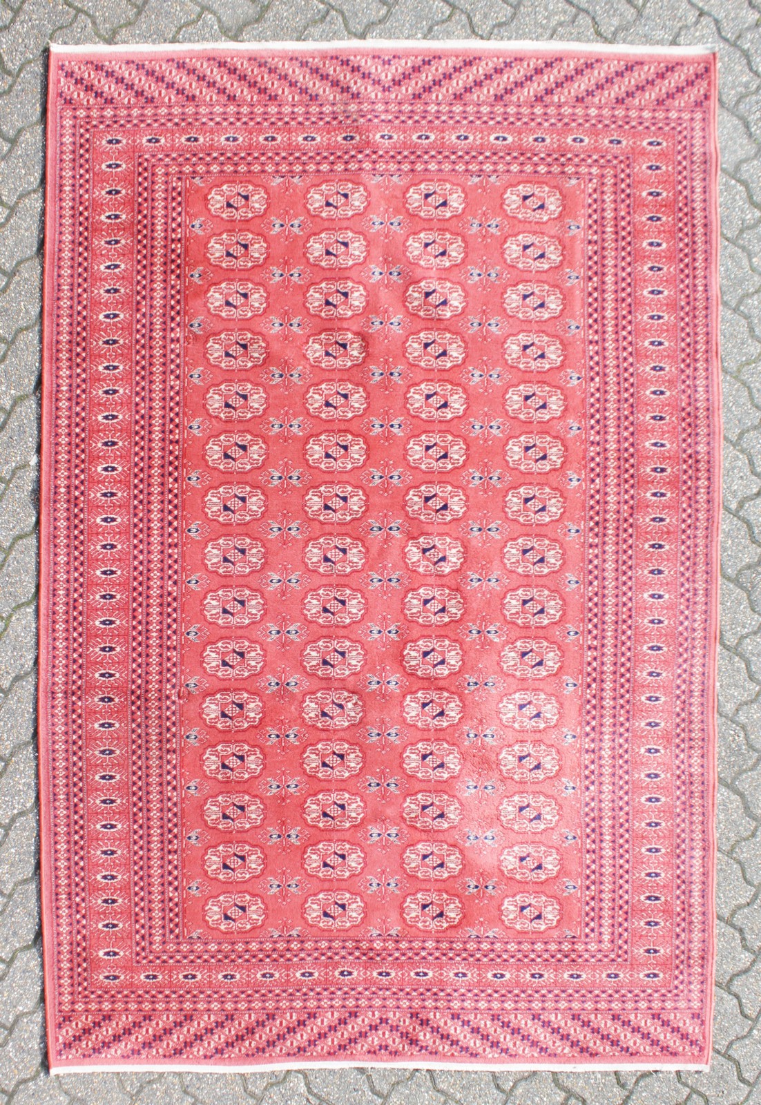 A BOKHARA CARPET, claret ground within lozenge border. 7ft 7ins x 5ft 5ins.