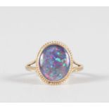 AN OVAL OPAL 9CT YELLOW GOLD RING.