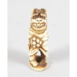 A STAG ANTLER GROTESQUE FIGURE NETSUKE. 6cms high.