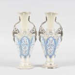 A PAIR OF SILVERED ISLAMIC TWO HANDLED VASES with blue panels and white overlay. 9ins high.