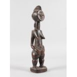 A TRIBAL CARVED WOODEN FEMALE STANDING FIGURE with geometric design. 9.5ins high.