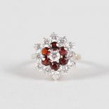 A GARNET AND BRILLIANT 9CT YELLOW GOLD DRESS RING.