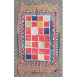 AN AZTEC STYLE RUG, within multi-coloured borders. 8ft 5ins x 4ft 9ins.