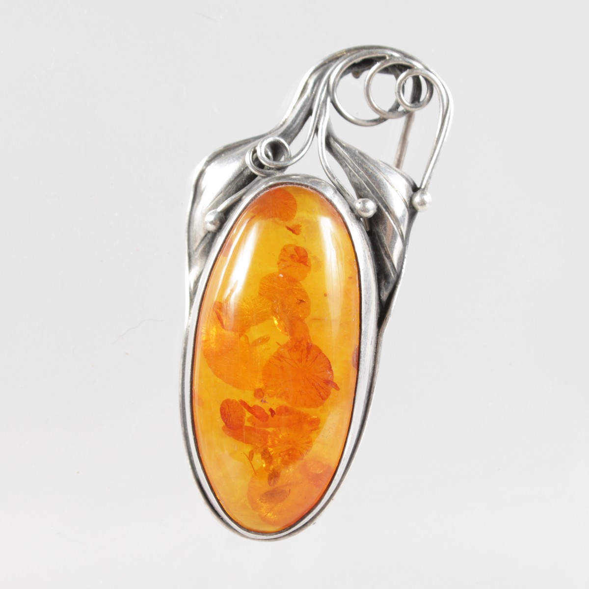 A SILVER AND AMBER ART DECO BROOCH.