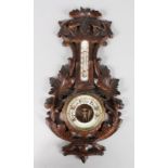 A CARVED WOOD THERMOMETER BAROMETER. 18ins long.