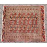 A BOKHARA RUG, salmon ground, within multiple geometric borders. 3ft 9ins x 3ft 4ins.