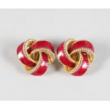 A PAIR OF RED ENAMEL AND GILT CROSSOVER EAR CLIPS.