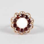 A GARNET AND OPAL 9CT YELLOW GOLD RING.