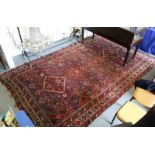A PERSIAN CARPET, claret and blue ground within a single border. 8ft x 13ft 6ins.