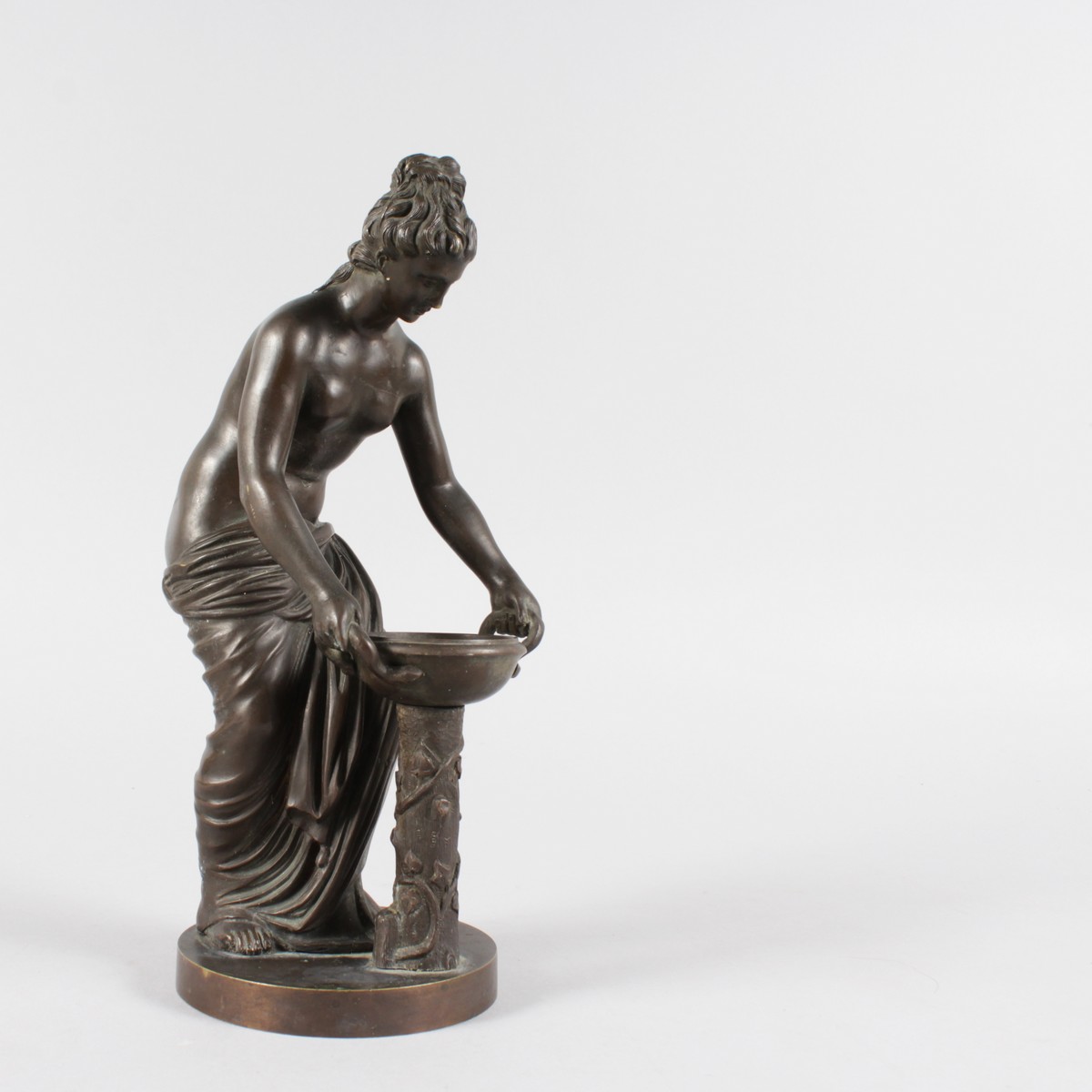 A 19TH CENTURY BRONZE FIGURE of a semi clad woman.