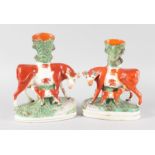 A PAIR OF STAFFORDSHIRE COW AND CALF SPILL VASES. 11ins high.