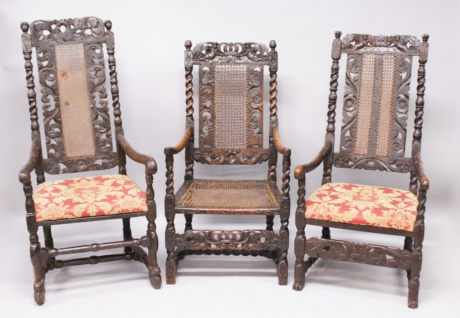 THREE LATE 17TH CENTURY WALNUT ARMCHAIRS, all with carved cresting rails, cane work back panels,