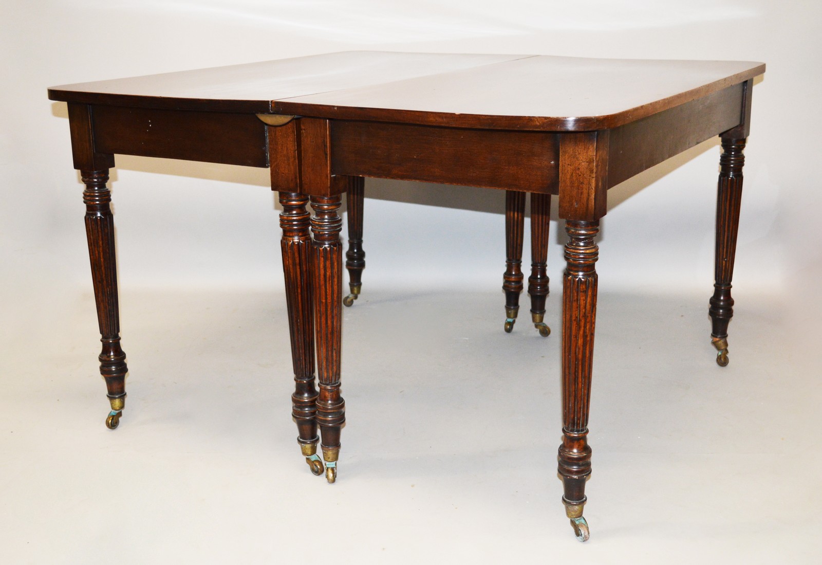 A 19TH CENTURY MAHOGANY EXTENDING DINING TABLE, In the Manner of Gillows, with a pair of rounded