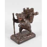 A GOOD 19TH CENTURY BLACK FOREST STANDING BEAR GLASS HOLDER, formed as a bear with stick, carrying a