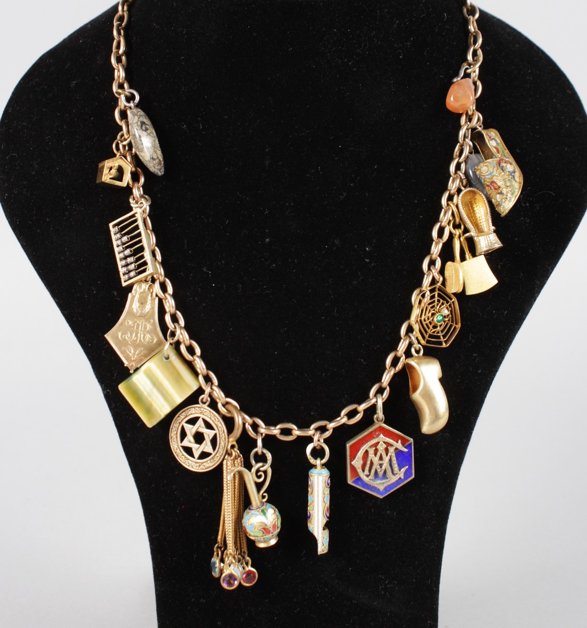 A LONG 9CT GOLD CHARM NECKLACE, some charms Jewish and Russian.