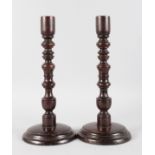 A PAIR OF 18TH-19TH CENTURY CARVED TREEN CANDLESTICKS. 16ins high.