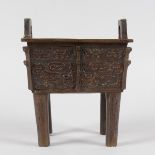A CHINESE BRONZE INCENSE BURNER with decorated sides, on four long legs. 6.5ins wide,