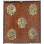 A RUSSIAN OAK PLAQUE with five brass ovals of saints.