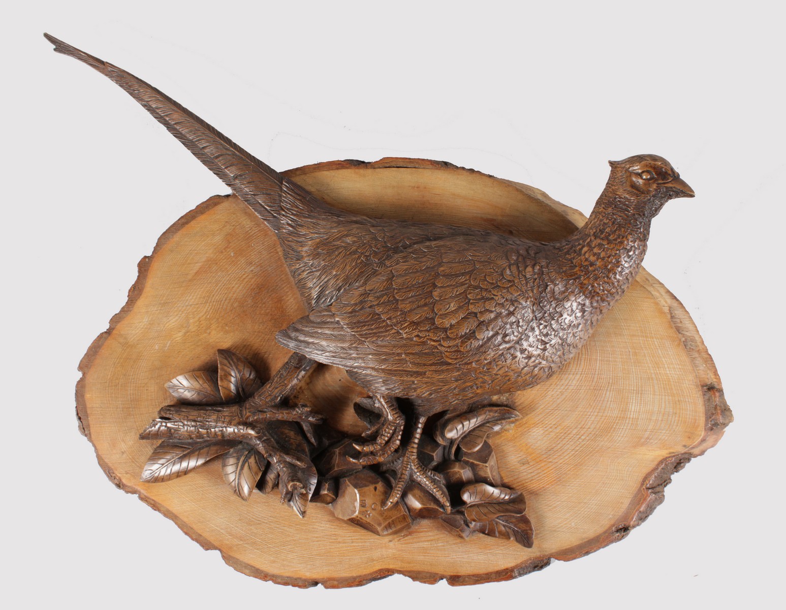 A CARVED WOOD WALL PLAQUE OF A PHEASANT. Monogrammed S.C. 26ins long overall.