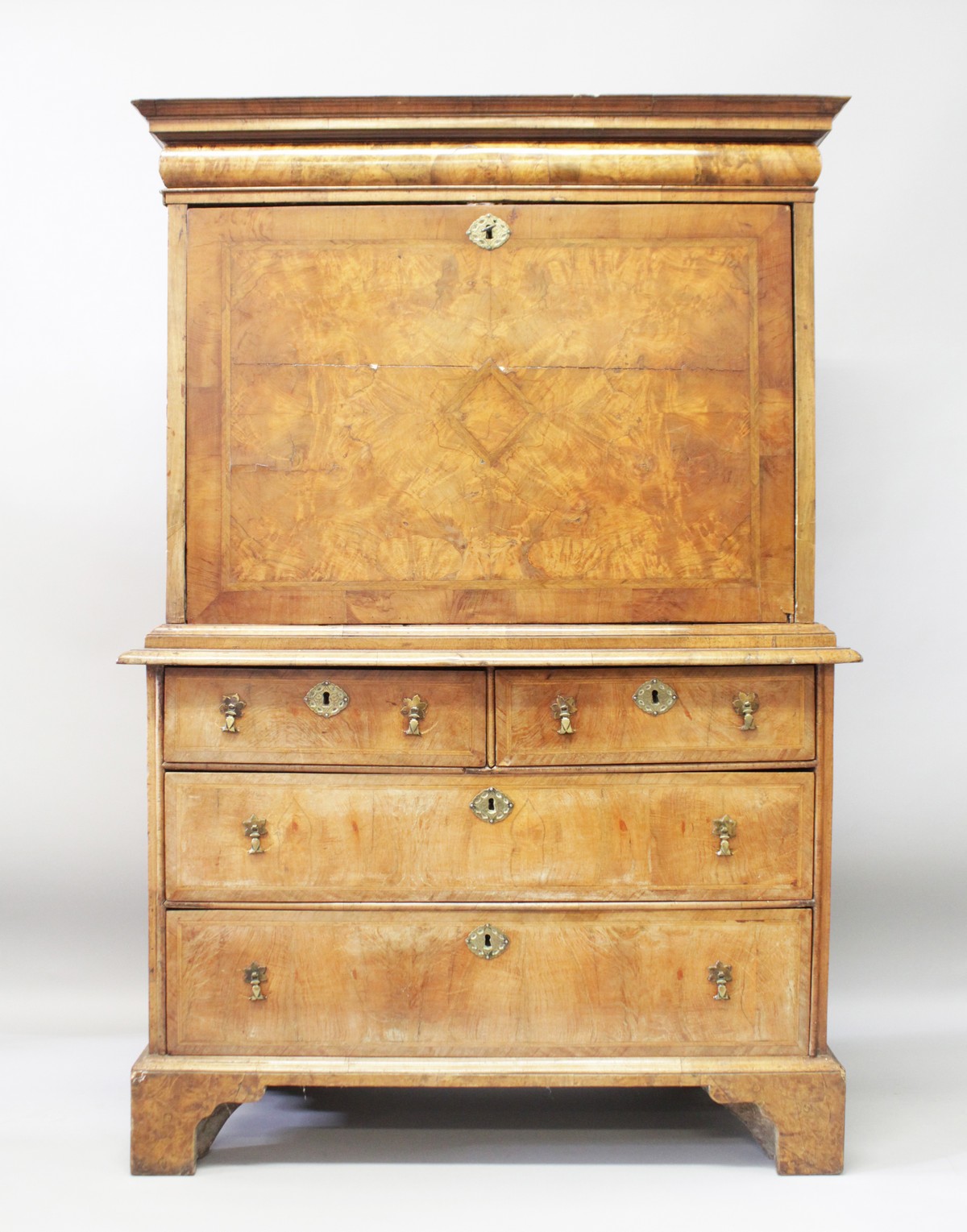 A QUEEN ANNE WALNUT ESCRITOIRE, with cushion drawer above a fall front, fitted interior over a