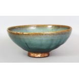 A CHINESE MING DYNASTY JUN WARE STONEWARE BOWL, applied with a pale blue glaze thinning to beige