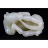 A CHINESE PALE CELADON JADE MODEL OF A HORSE, lying on its side, 2.25in(5.8cm) wide.