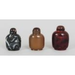 A GROUP OF THREE CHINESE GLASS SNUFF BOTTLES & STOPPERS, simulating hardstones, the tallest 2.25in(