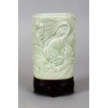 A 19TH CENTURY CHINESE CELADON MOULDED PORCELAIN BRUSHPOT, together with a fitted carved hardwood