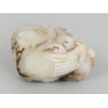 A CHINESE JADE CARVING OF A DUCK, clasping a frond of lingzhi in its beak, the stone of