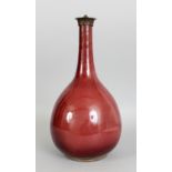 A CHINESE 18TH CENTURY SANG-DE-BOEUF PORCELAIN BOTTLE VASE, with a fixed bronze neck fitting, the