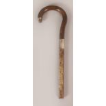 A HORN HANDLE, possibly rhinoceros horn, with a hallmarked silver collar and part of a stick