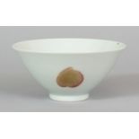 A CHINESE COPPER RED CONICAL PORCELAIN BOWL, decorated with two peach and a pomegranate, the base