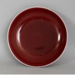 A CHINESE QIANLONG MARK & PERIOD COPPER RED PORCELAIN SAUCER DISH, the glaze thinning to white at