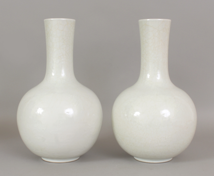 A PAIR OF 18TH/19TH CENTURY CHINESE WHITE GLAZED PORCELAIN BOTTLE VASES, each decorated in white