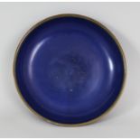 A CHINESE 17TH/18TH CENTURY CHINESE BLUE GLAZED PORCELAIN SAUCER DISH, the glaze thinning at the