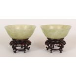 A NEAR PAIR OF GOOD QUALITY 19TH/20TH CENTURY CHINESE JADE BOWLS, with fitted carved hardwood