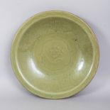 A LARGE CHINESE YUAN/MING DYNASTY LONGQUAN CELADON STONEWARE DISH, lightly moulded beneath the glaze