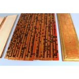 A BURMESE LACQUERED WOOD SUTRA, dated 1905, with numerous inscribed leaves, the covers 22in(56cm)