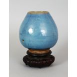 A CHINESE MING DYNASTY JUN WARE LOTUS WATER POT, together with a fitted wood stand, the blue glaze
