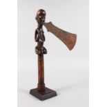 A LUBA CARVED WOOD CEREMONIAL AXE, with carved wooden female holding an engraved copper axe. 12ins