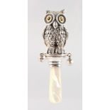 A SILVER AND MOTHER-OF-PEARL OWL RATTLE.