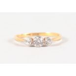 AN 18CT YELLOW GOLD THREE STONE DIAMOND RING.