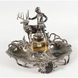 A GOOD 19TH CENTURY WMF PLATED INKWELL, a man with a deer, ivy and musical trophies. 12ins wide.
