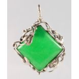 A JADE SILVER MOUNTED PENDANT.