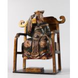 A CHINESE CARVED WOOD MAN seated in a chair. 10ins high.