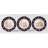 A SET OF THREE SEVRES CIRCULAR SHAPED PLATES, blue borders, the centre decorated with a gallant